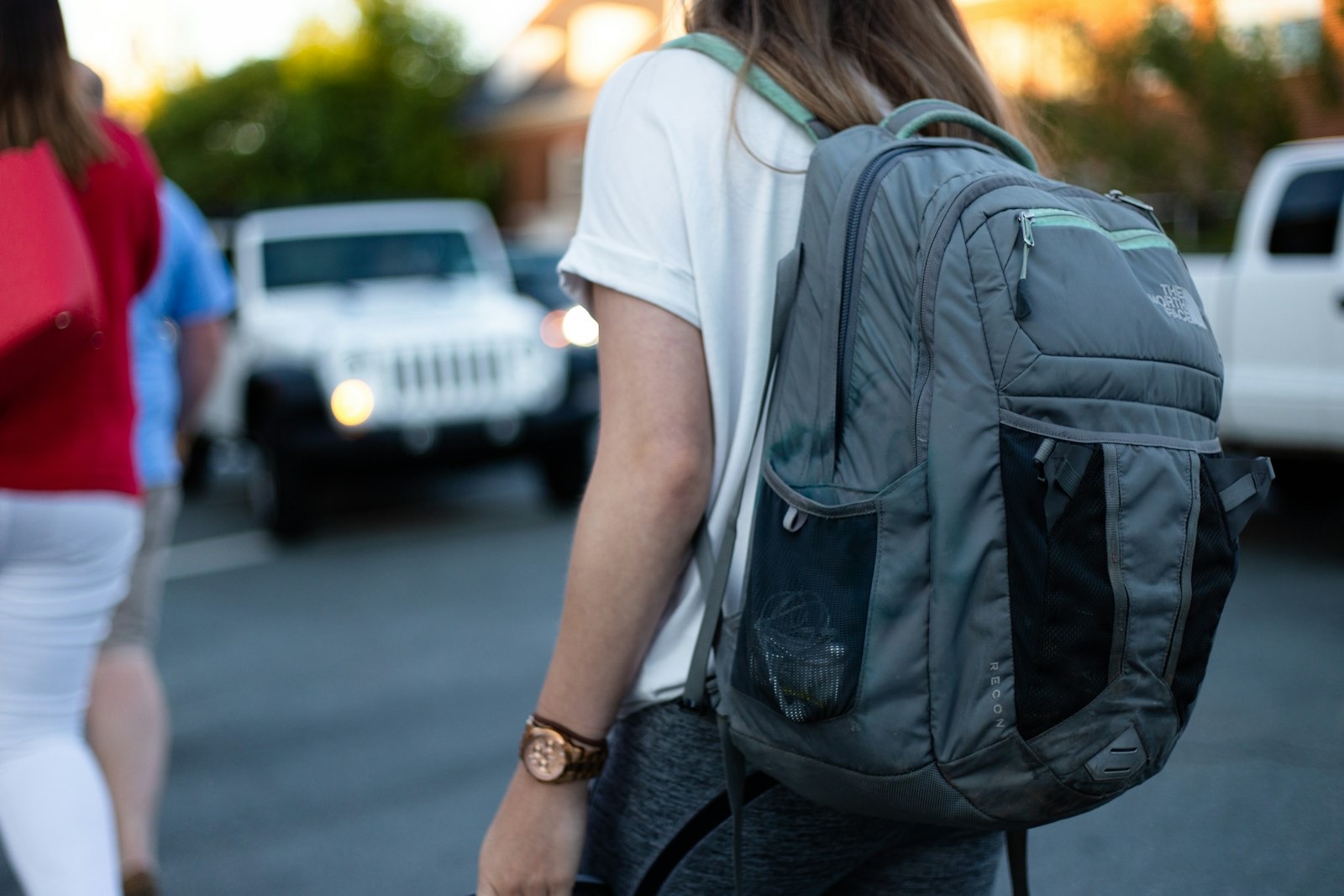 Woman carrying a backpack with the strap across her shoulder