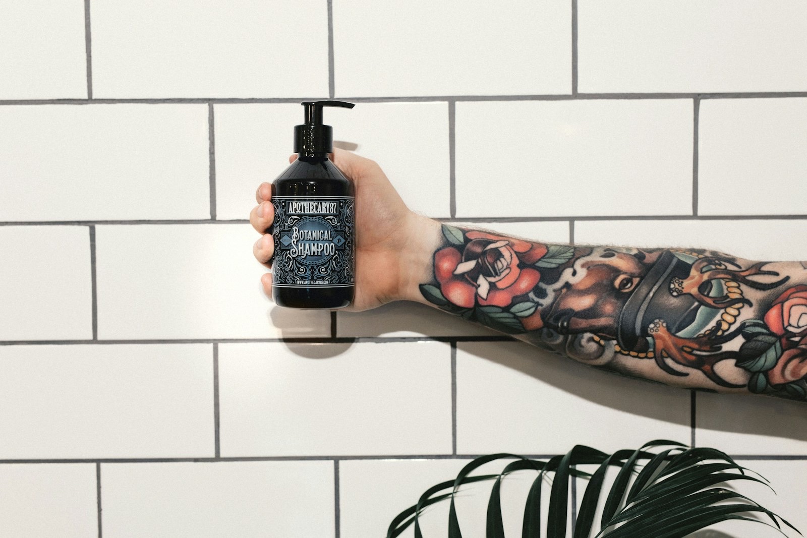 Person holding a black plastic skincare bottle