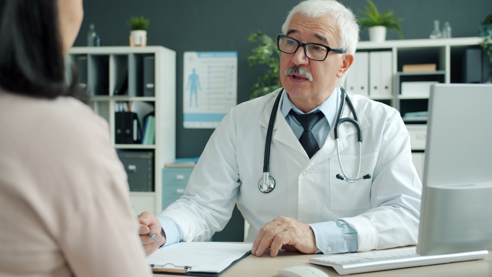 A clinician talking with a patient across a desk
