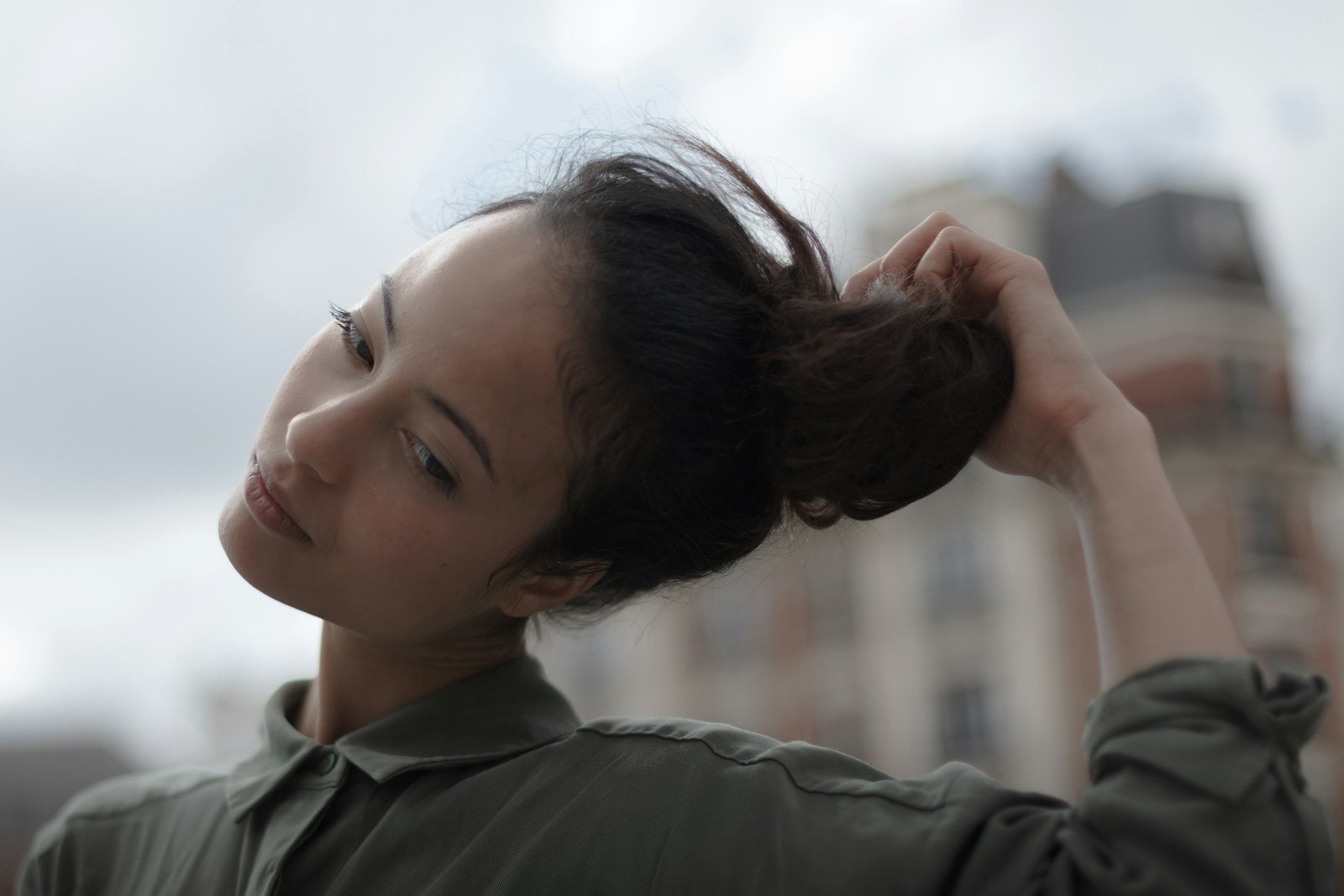 A woman holding her hair back from her face